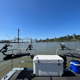 Four rods with lines set off the back of a boat with bridges in the background.