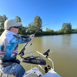 Angler fighting a sturgeon on the Fraser River during a fishing trip in Vancouver, BC